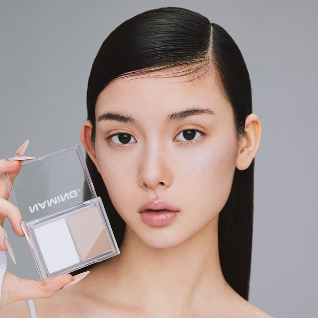 Décris l’image en français : NAMING Fluffy Volume & Shading Duo, maquillage yeux, modèle face à fond clair, en studio.