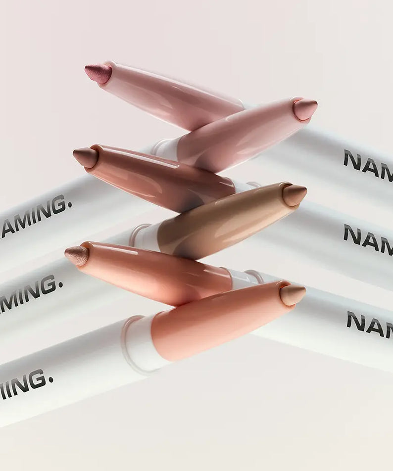 NAMING Pencil Dual Liner : crayons double liner NAMING en teintes nude, sur fond blanc, mise en scène produit.