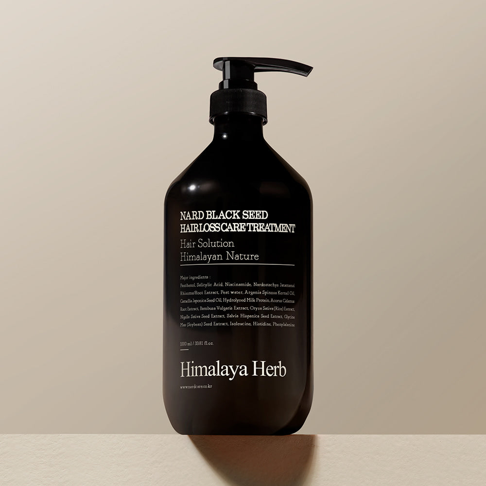 Décris l'image en français : NARD Black Seed Hair Loss Treatment 1000ml de marque NARD, flacon noir pompe, fond clair.