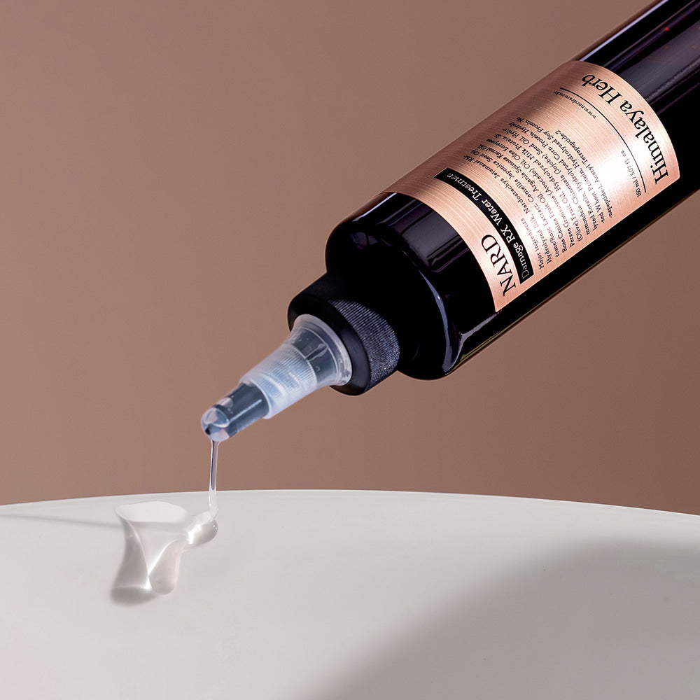 NARD Damage RX Water Treatment 150ml, marque NARD, flacon noir verse un gel blanc sur surface blanche.