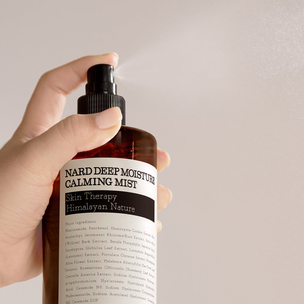 NARD Deep Moisture Soothing Mist 500ml de NARD, main tenant le flacon sur fond clair, spray visage apaisant.