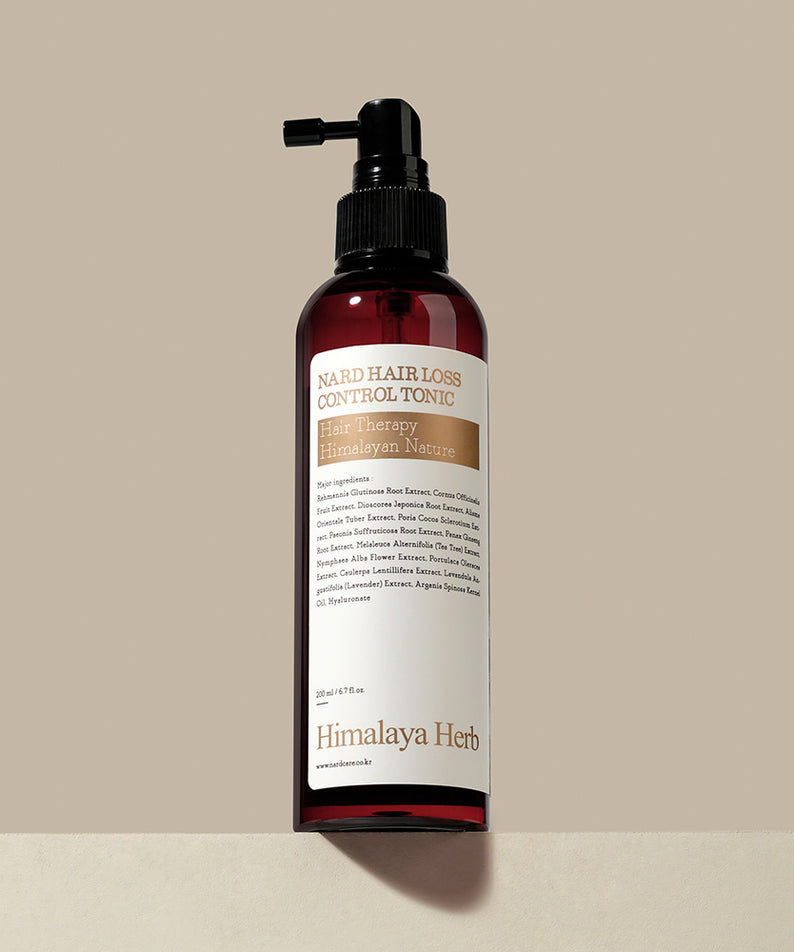 NARD Hair Loss Relief Hair Tonic 200ml de la marque NARD, flacon rouge avec pompe, sur fond beige (produit beauté capillaire).