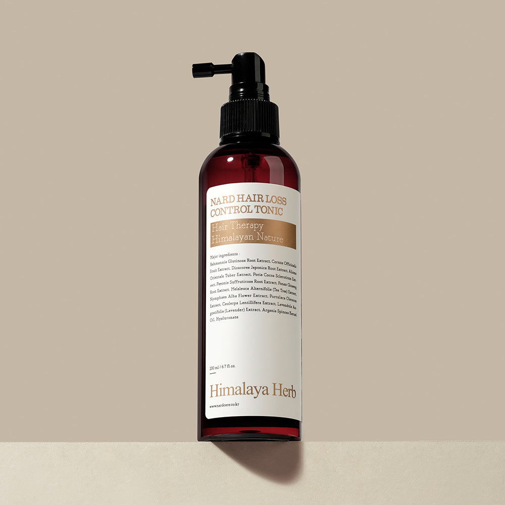 NARD Hair Loss Relief Hair Tonic 200ml de la marque NARD, flacon rouge avec pompe, sur fond beige (produit beauté capillaire).