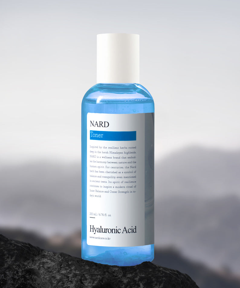 NARD Low-Molecular Deep Moisture Hyaluronic Acid Toner 200ml NARD, bouteille sur fond pierre et brume, flacon bleu clair