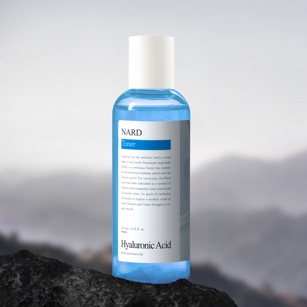 NARD Low-Molecular Deep Moisture Hyaluronic Acid Toner 200ml NARD, bouteille sur fond pierre et brume, flacon bleu clair