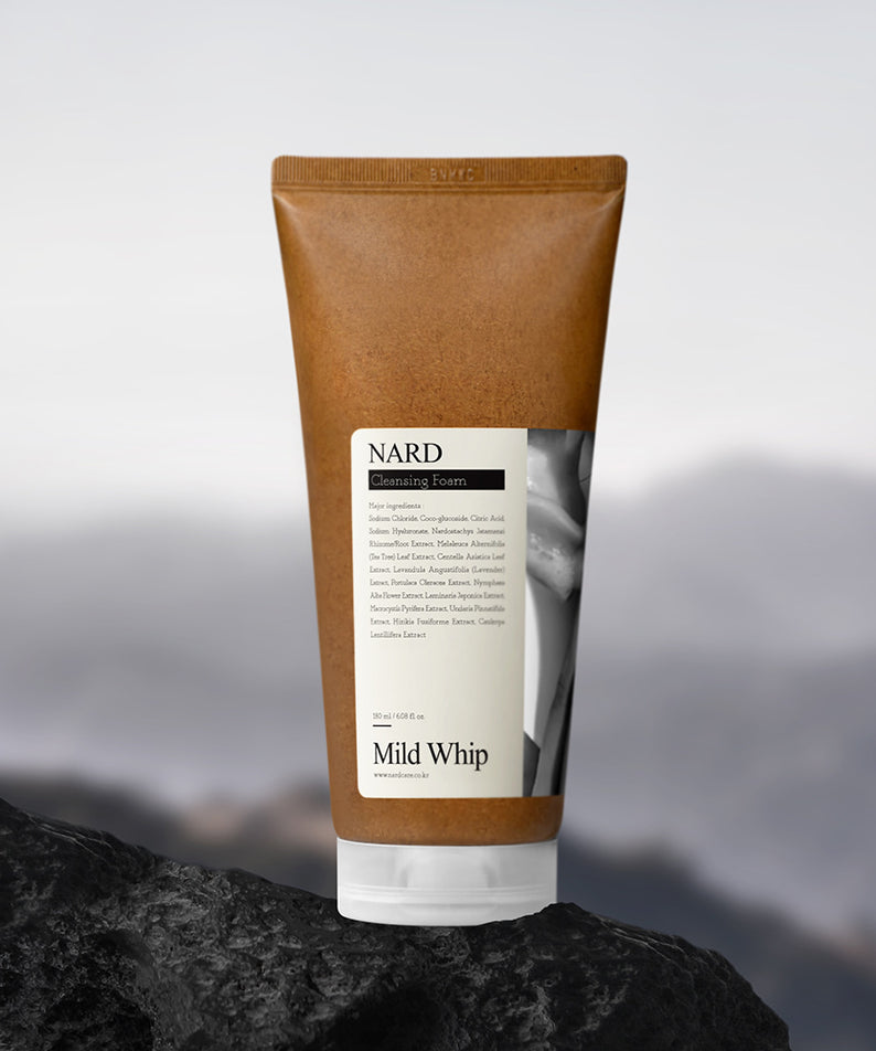NARD Mild Whip Pore Cleansing Foam 180ml sur fond montagne et rocher, tube moussant de NARD, ambiance beauté.
