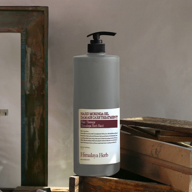 NARD Moringa Oil Damage Care Treatment 1500ml, flacon NARD sur caisse bois, éclairage doux, contexte boutique.