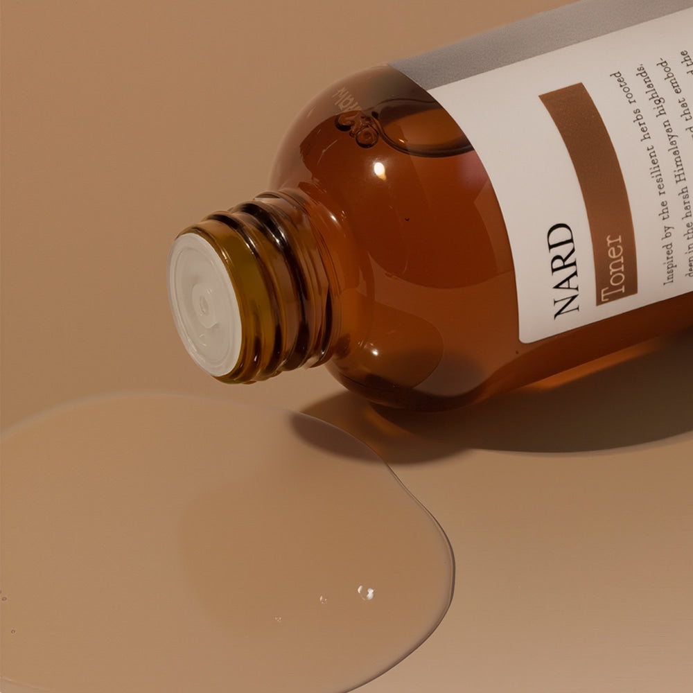 NARD Propolis Infusing Toner 200ml de NARD, flacon ambre verse sur fond beige, ambiance beauté spa.