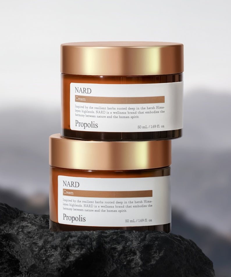 NARD Propolis Nourishing Cream 50ml de NARD, pot crème doré sur pierre noire, fond minimaliste.