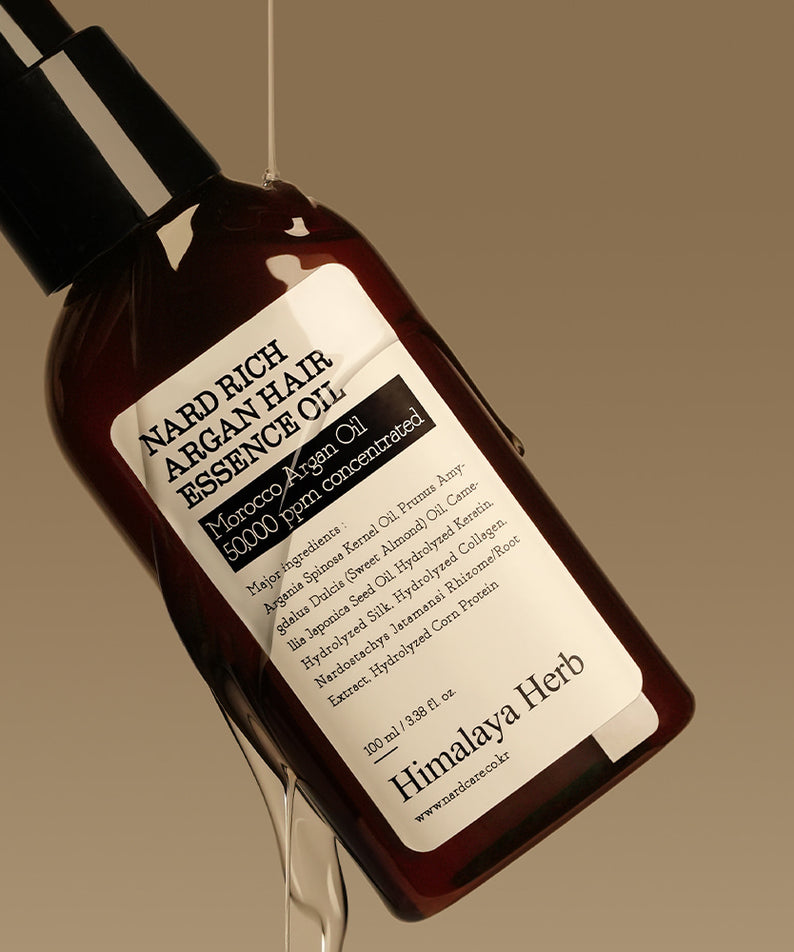 Photo produit : NARD Rich Argan Hair Essence Oil 100ml de la marque NARD, flacon brun sur fond beige, ambiance beauté.