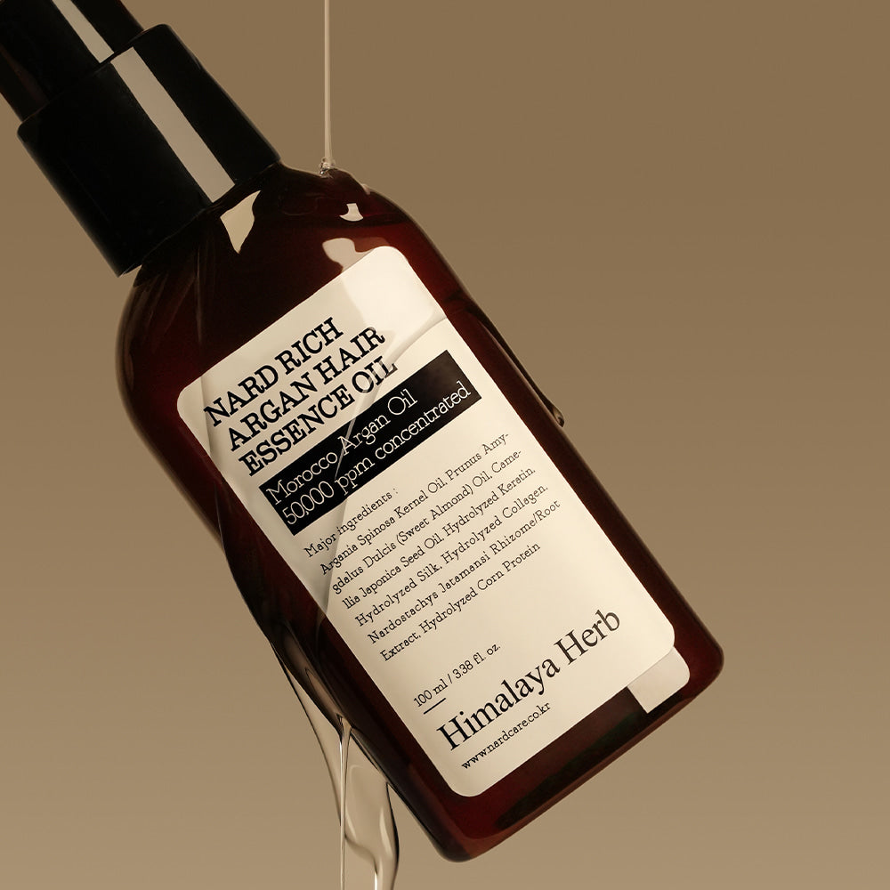 Photo produit : NARD Rich Argan Hair Essence Oil 100ml de la marque NARD, flacon brun sur fond beige, ambiance beauté.