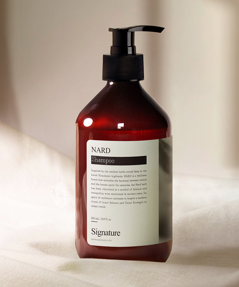 NARD Signature Shampoo 500ml, flacon NARD rouge sur fond crème, pompe noire, photo produit en studio