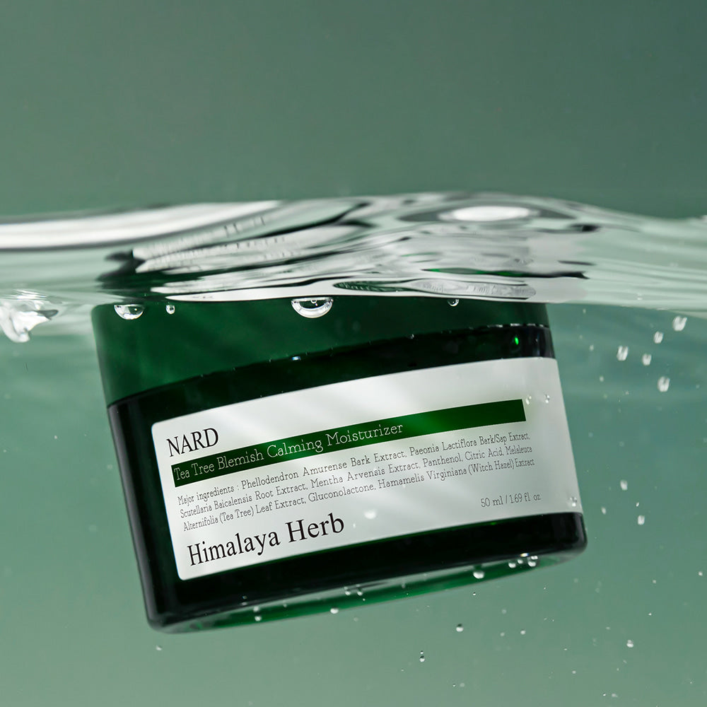 NARD Tea Tree Blemish Soothing Moisture Cream 50ml, crème NARD en flacon sur fond vert, gouttes d’eau.
