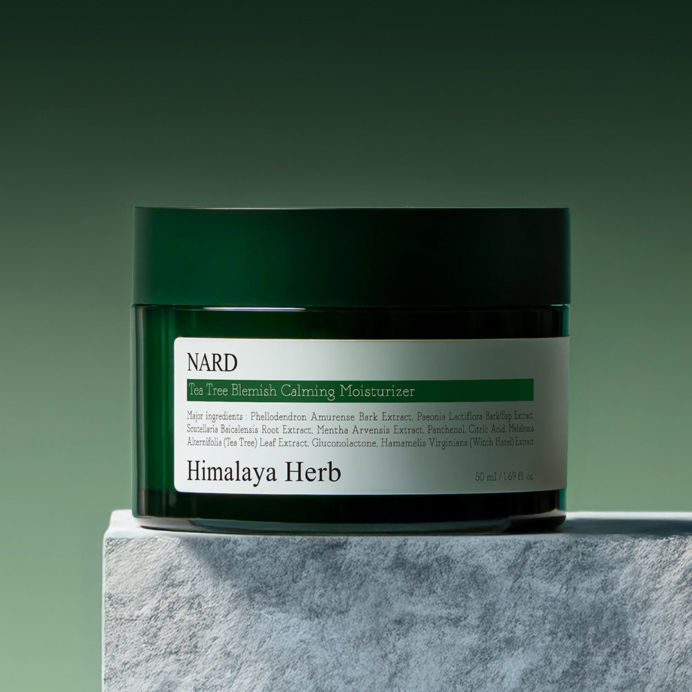 NARD Tea Tree Blemish Soothing Moisture Cream 50ml, pot de crème vert sur support gris, peau et huile d’arbre à thé