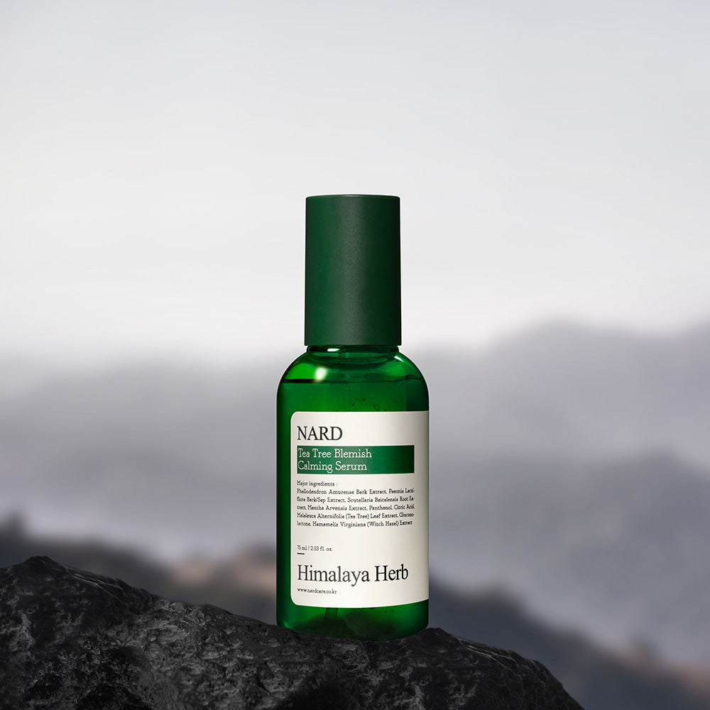 Photo produit NARD Tea Tree Blemish Soothing Serum 75ml de la marque NARD, sur roche devant montagnes, style naturel