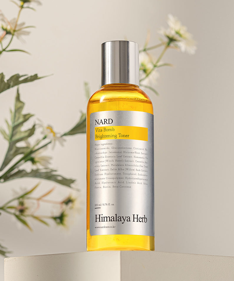 NARD Vita Balm Brightening Toner 200ml NARD, flacon doré sur fond crème avec plantes en contexte beauté naturel
