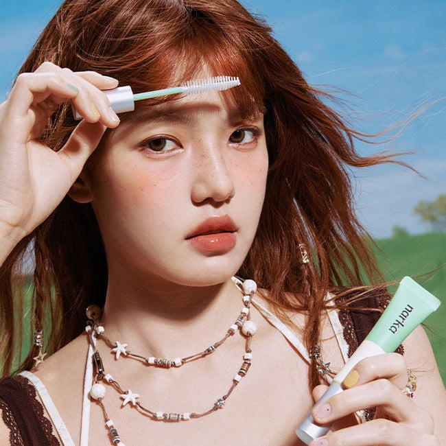 NARKA Fresh Sebum Hair Mascara de la marque NARKA : femme l’applique sur ses cheveux, ciel et nature en arrière-plan.