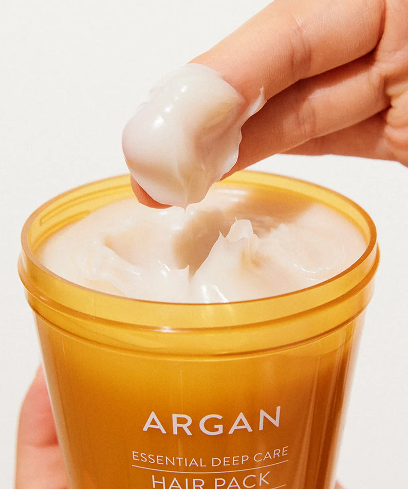 NATURE REPUBLIC Essential Deep Care Hair Pack 470ml, pot d’argan ouvert, main appliquant la crème, gros plan sur le produit