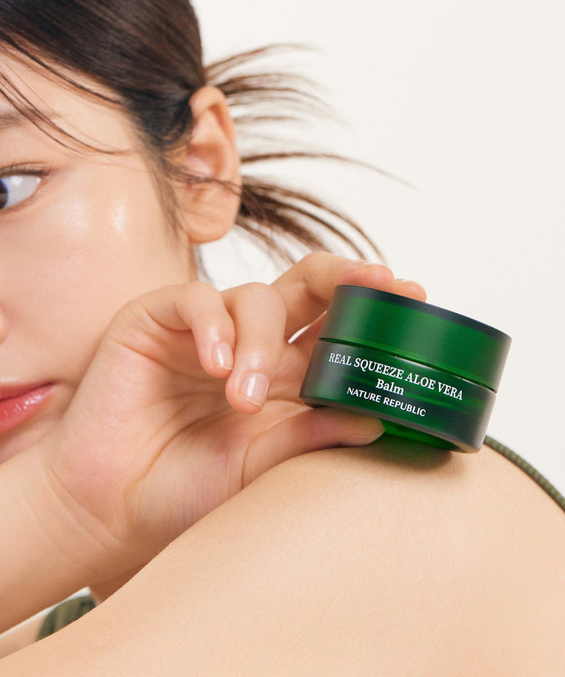Femme tenant le NATURE REPUBLIC Real Squeeze ALoe Vera Balm 25g, hydratant pour visage, peau éclatante.