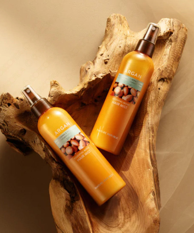 Deux bouteilles de NATURE REPUBLIC Essential Moisture Hair Mist 220ml posées sur une surface en bois.
