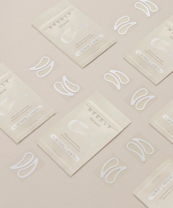 NEEDLY Eye Patch en emballage beige, patches hydratants pour les yeux disposés sur une surface, soin pour revitaliser le contour des yeux.