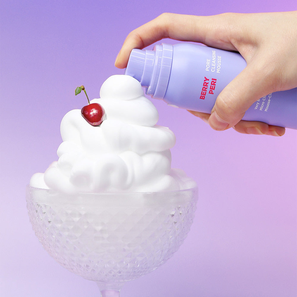 Main versant la mousse NEOGEN Berry Peri Pore Cleansing Mousse 150ml, avec cerises sur fond violet.