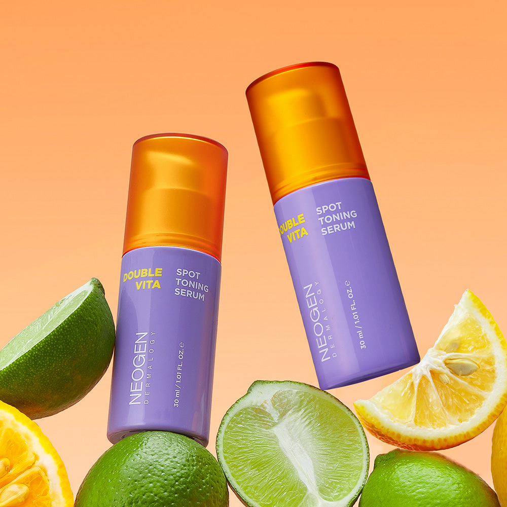 Décris l'image en français mentionnant NEOGEN Double Vita Spot Toning Serum 30ml, la marque et des agrumes sur fond orange.