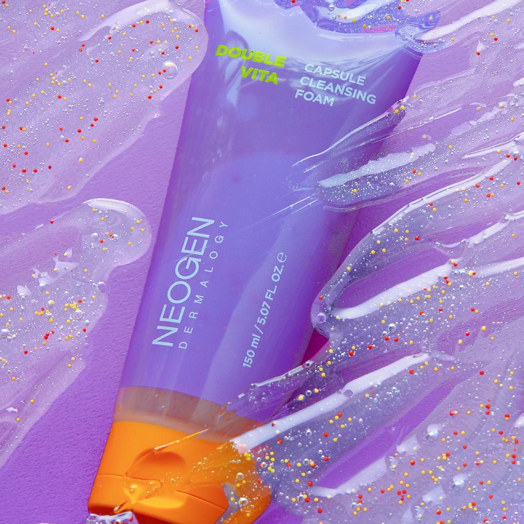 NEOGEN Dounble Viita Capsual Cleansing Foam 150ml : tube violet et mousse, confettis colorés sur fond esthétique.