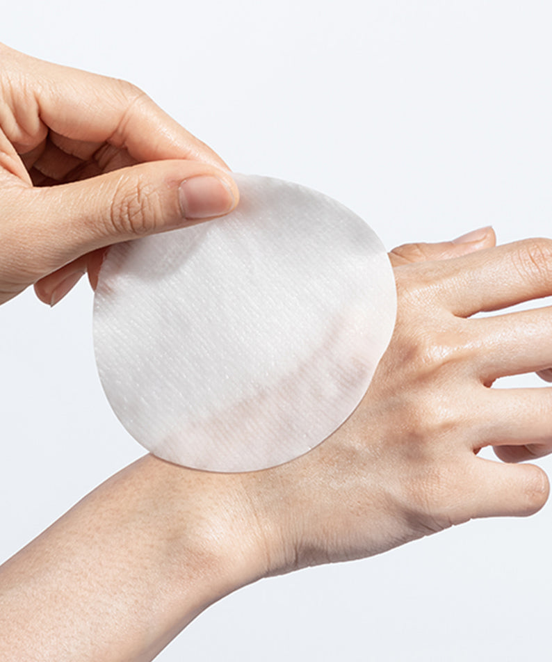 NEOGEN Niacinamide Glow Up Daily Mask Pads 40 Sheets, marque NEOGEN : main tenant un pad blanc, sur fond clair