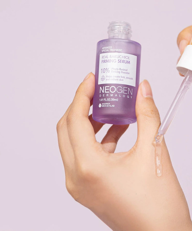 NEOGEN Real Bakuchiol Firming Serum 30ml de la marque NEOGEN, mains appliquant le sérum sur fond violet clair.