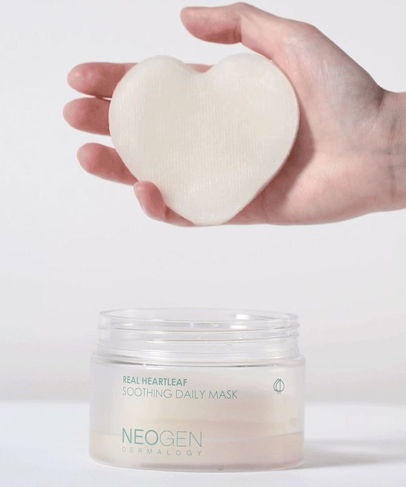 NEOGEN Real Heartleaf Soothing Daily Mask 40 Sheets, masque en tissu cœur tenu en main et pot sur fond clair