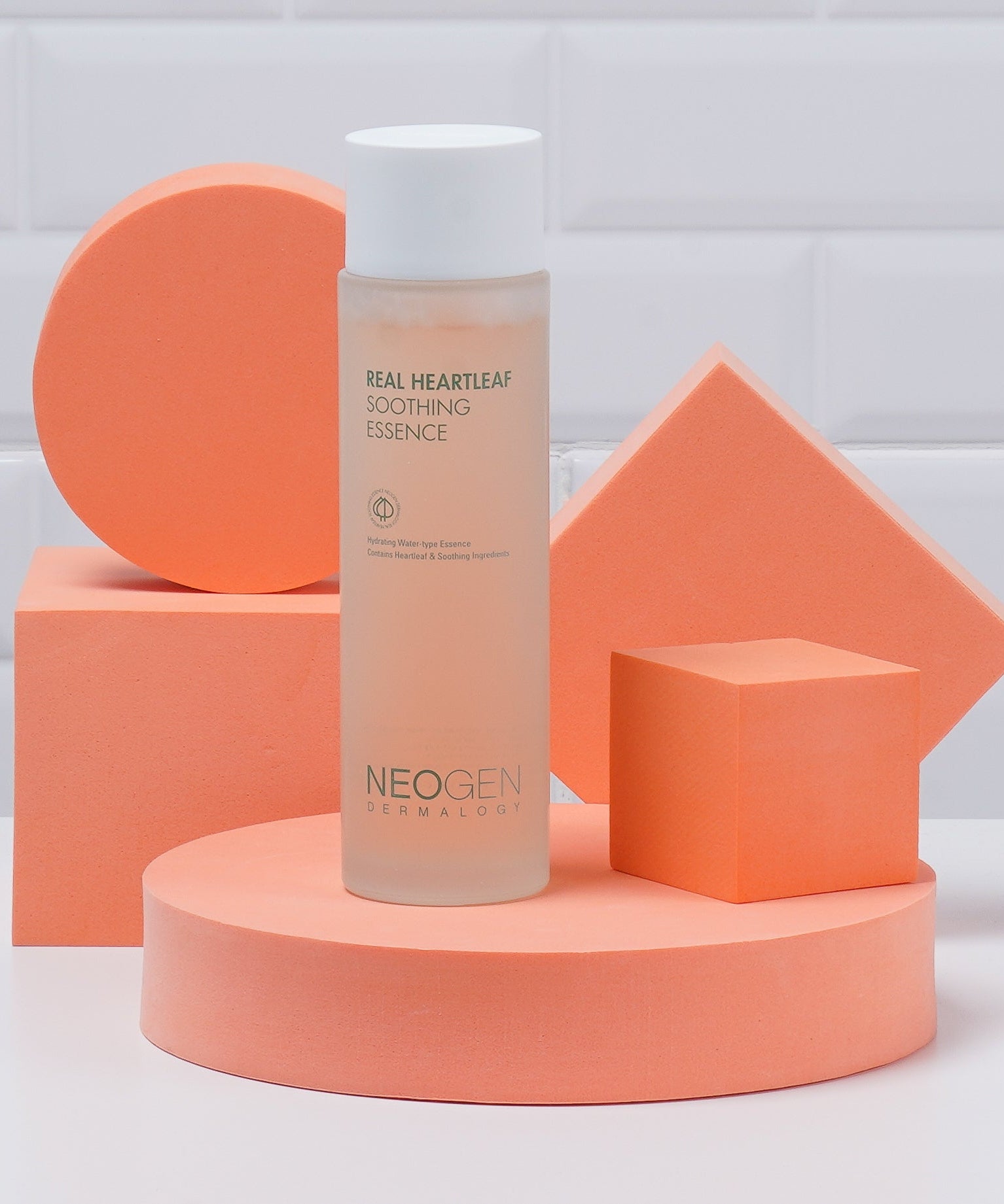 NEOGEN Real Heartleaf Soothing Essence 150ml, flacon sur podium orange en studio, mise en scène beauté.