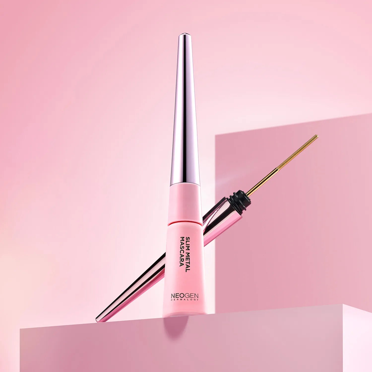 NEOGEN  Slim Metal Mascara 6ml de NEOGEN, flacon et brosse sur fond rose tendance, maquillage yeux.