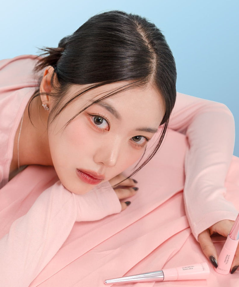 NEOGEN  Slim Metal Mascara 6ml de la marque NEOGEN, présentée en maquillage sur fond bleu avec modèle en rose.
