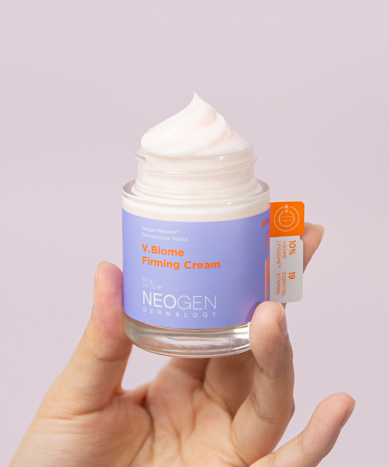 NEOGEN V Biome Firming Cream 60g, crème raffermissante de NEOGEN Dermalogy en pot, mains tenant le produit sur fond clair.