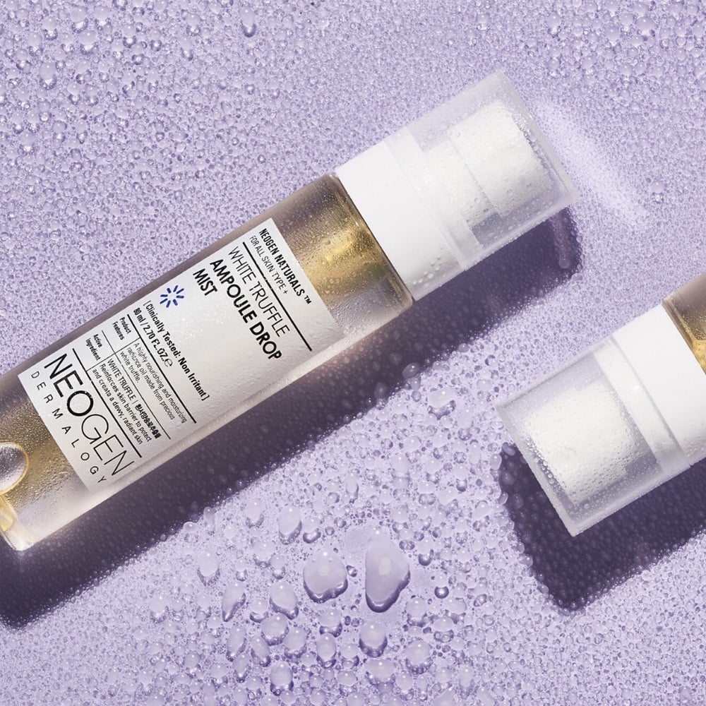 NEOGEN White Truffle Ampoule Drop Mist 80ml de NEOGEN, flacon sur fond violet avec gouttes d’eau, ambiance beauté spa