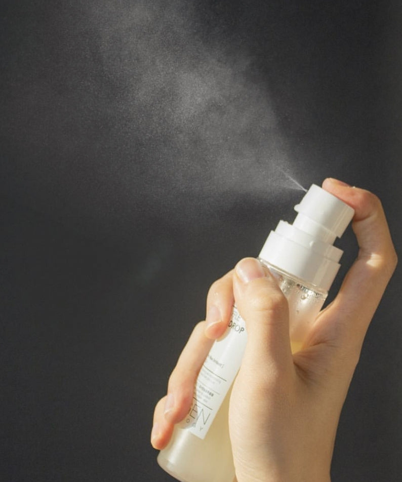 NEOGEN White Truffle Ampoule Drop Mist 80ml, main tenant le flacon, contexte beauté sur fond sombre, marque NEOGEN