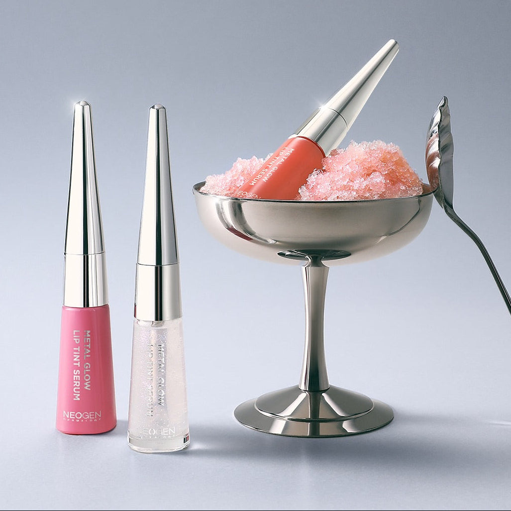 NEOGEN Metal Glow Lip Tint Serum NEOGEN, flacons de gloss lumineux sur fond clair, avec effet pailleté.