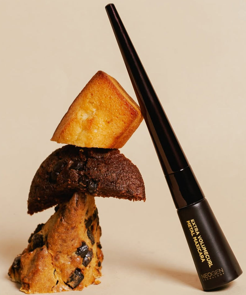 NEOGEN Volume Curl Matal Mascara Brown 4ml avec desserts en arrière-plan. Mascara volume et courbure parfaits.