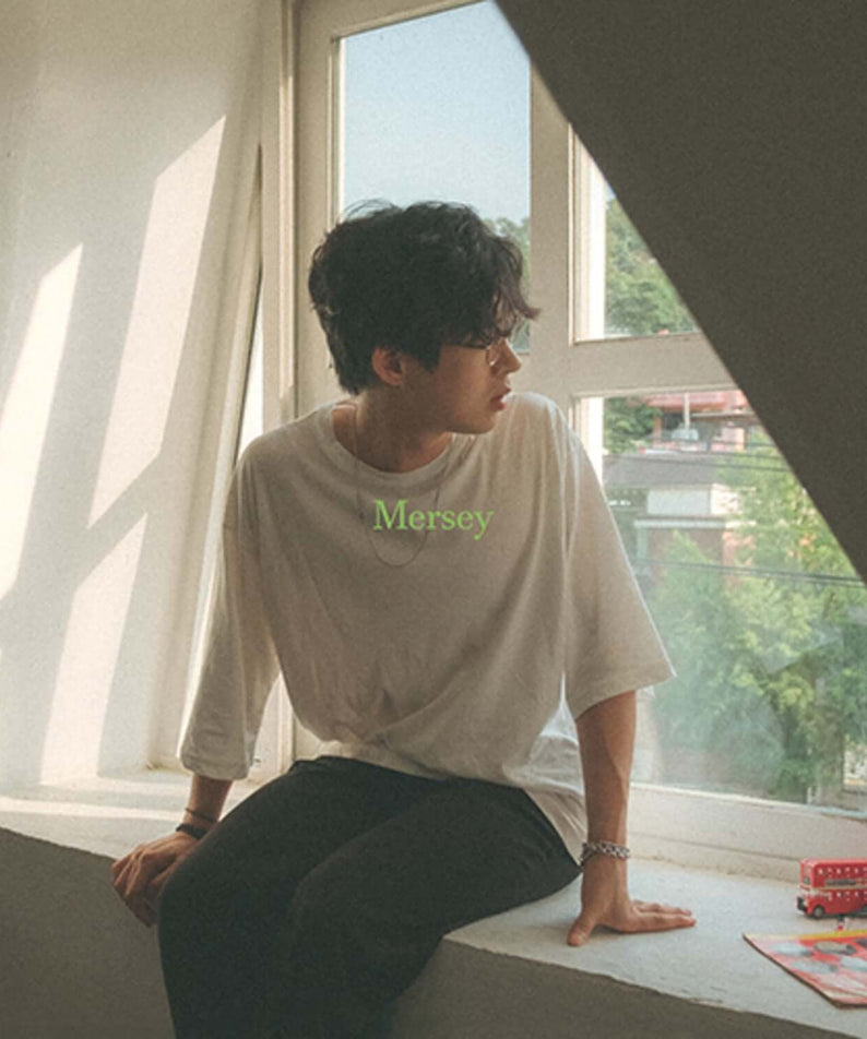 NOKDU - MERSEY - Album Kpop par NOKDU, visuel intérieur avec jeune assis près des mangas et couvertures.