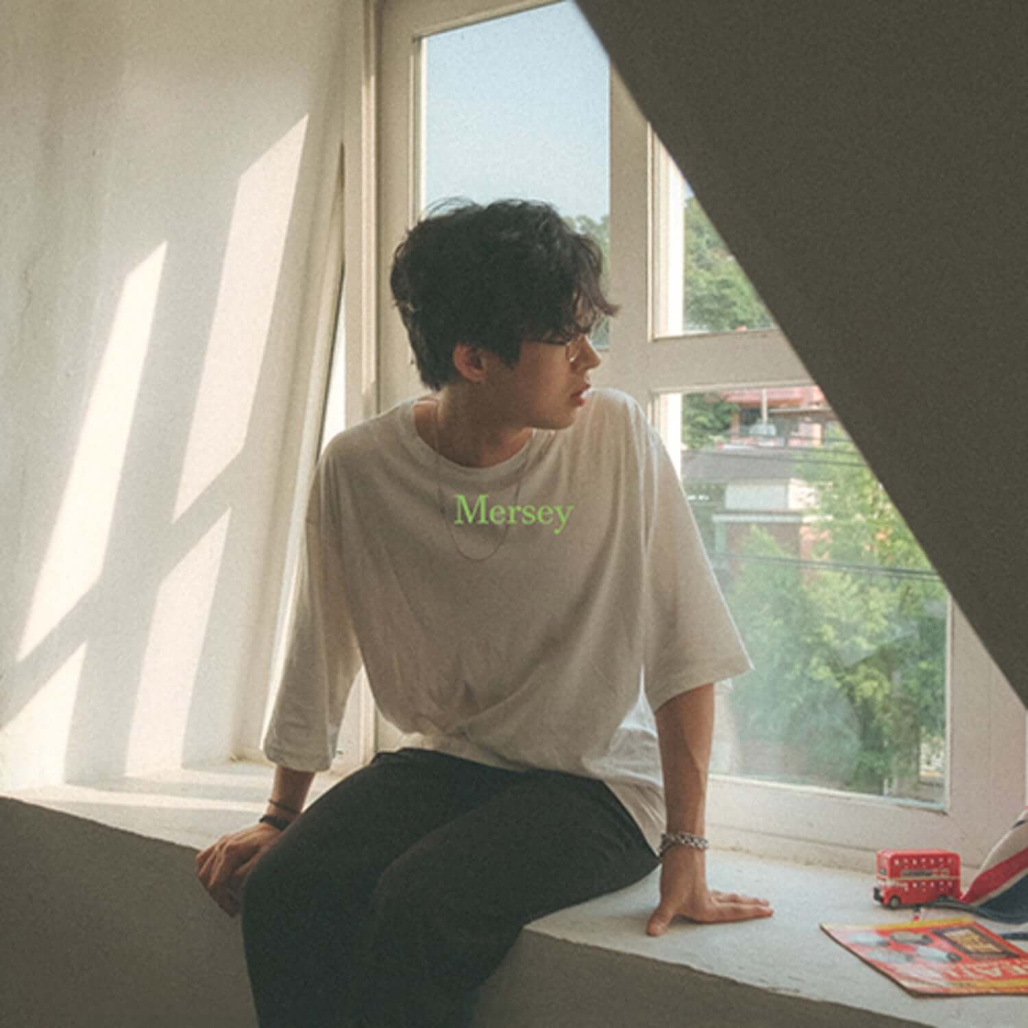 NOKDU - MERSEY - Album Kpop par NOKDU, visuel intérieur avec jeune assis près des mangas et couvertures.