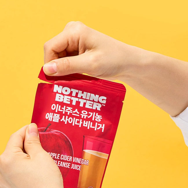 Main tenant NOTHING BETTER Inner Juice Apple Cider Vinegar Cleanse Juice (X24), sachets rouges sur fond jaune