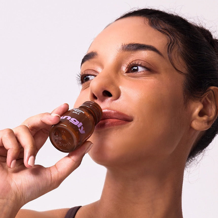 NOTHING BETTER Tangly Slimming Shot 7 Bottles, femme boit un shot, marque NOTHING BETTER, fond clair, visuel produit