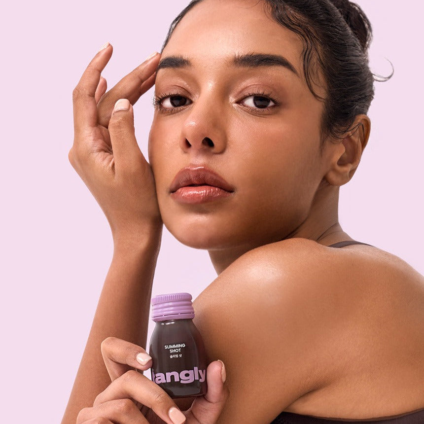 NOTHING BETTER Tangly Slimming Shot 7 Bottles de la marque Nothing Better sur une femme, flacon rose, fond rose.