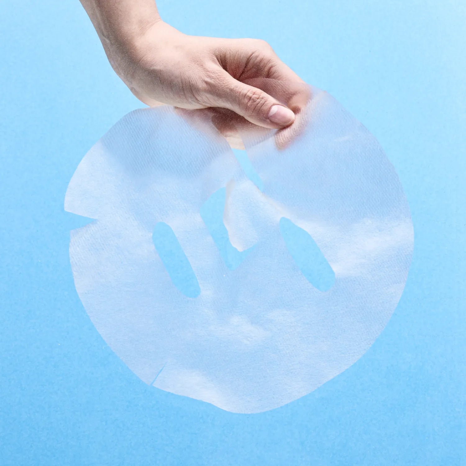 NUMBUZIN No.1 Hyaluronic Panthenic Acid Clear Soothing Gauze Pack 10 sheets, mains tenant une compresse apaisante sur fond bleu