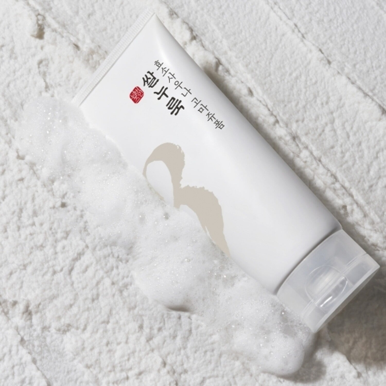 Décris l'image en français : NUMBUZIN No.3 Rice Yeast Enzyme Suana Gommage Foam 170ml, marque NUMBUZIN, sur mousse blanche.