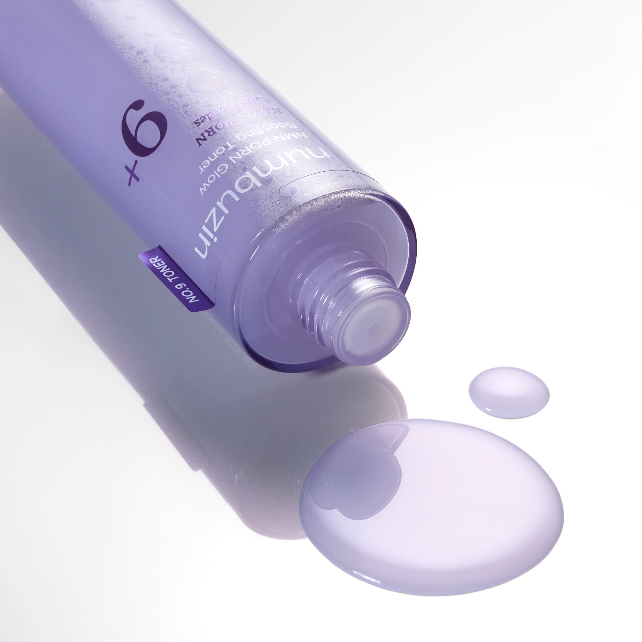 NUMBUZIN No.9 NMN PDRN Glow Boosting Toner 150ml, marque sur flacon violet, émulsion sur fond blanc, gros plan