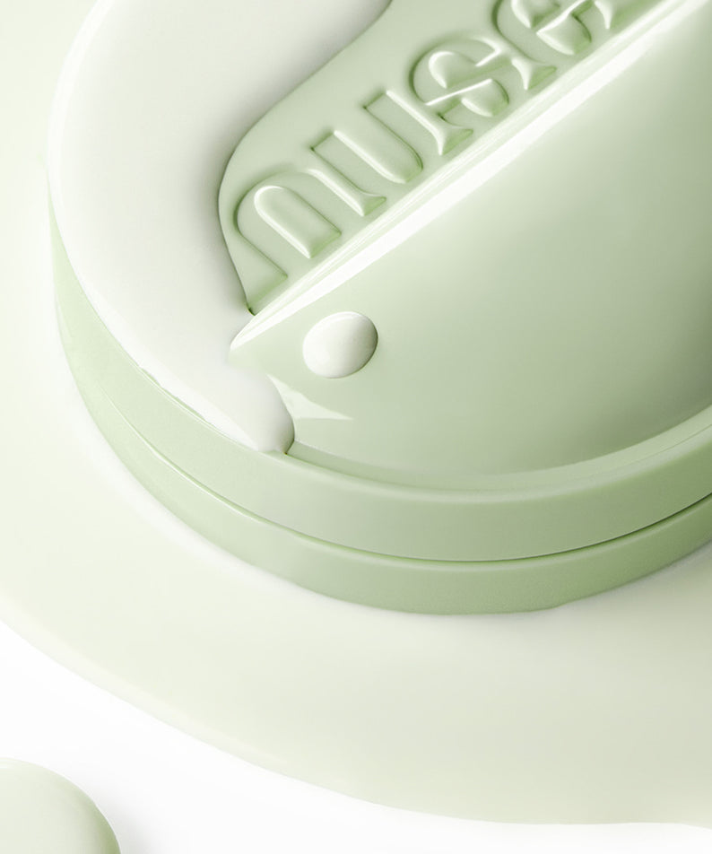 NUSE 1+1 Reju Toning Sun Cushion de NUSe, gros plan sur le coussin vert, texture crème et lumière douce.