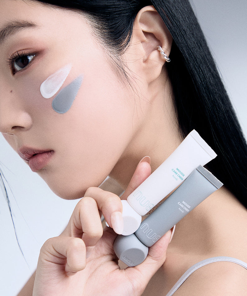 Femme tenant des tubes NUSE Mousse Care Cheek Handy avec des échantillons de produit sur la joue, illustrant la routine de soin du visage.