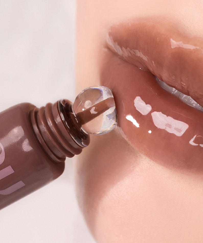 NUSE Nuzzle Reju Lip Gloss, gros plan sur l’embout appliquant un gloss brillant sur les lèvres, marque NUSE.